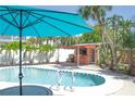 Inviting backyard oasis with refreshing swimming pool, bar area, and tropical landscaping at 340 81St Ave, St Pete Beach, FL 33706