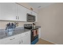 Updated kitchen featuring granite countertops, white cabinets, and stainless steel appliances at 3803 Cortez Cir # C, Tampa, FL 33614