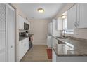 Updated kitchen featuring granite countertops, white cabinets, and stainless steel appliances at 3803 Cortez Cir # C, Tampa, FL 33614