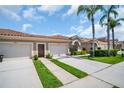 Townhome featuring a terra cotta roof, attached garages, and meticulous landscaping at 3885 Timber Ridge Ct, Palm Harbor, FL 34685