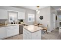 White kitchen featuring an island, stainless appliances, and an adjacent breakfast nook at 3885 Timber Ridge Ct, Palm Harbor, FL 34685