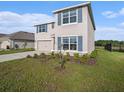 Attractive two-story home boasts tidy landscaping, double-car garage, and contrasting blue shutters and front door at 4114 Dovetail Ln, Palmetto, FL 34221
