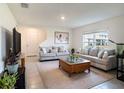 Bright living room features neutral paint, plush seating, tiled floors, and a window view of the neighborhood at 4114 Dovetail Ln, Palmetto, FL 34221