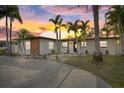 Charming single-story home featuring a well-manicured yard with lush tropical landscaping and an inviting entrance at 504 Driftwood E Dr, Palm Harbor, FL 34683