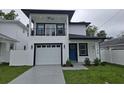 Two-story home with white exterior, black trim, balcony, blue front door, well-kept lawn and driveway at 5730 66Th Ln N, St Petersburg, FL 33709