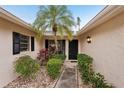 Inviting entrance featuring a palm tree, plants, and pathway to the front door at 7094 Fairway Bend Cir # 7094, Sarasota, FL 34243