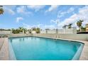Community pool with white fence, ample lounge chairs, and lush palms for a relaxing experience at 7321 Central Ave # 203, St Petersburg, FL 33710