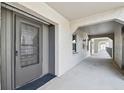 Hallway view showing neutral paint and flooring and multiple entrance doors with a textured ceiling for comfortable living at 8703 Bardmoor Blvd # 203, Seminole, FL 33777