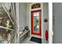 Elegant red front door with glass insert, complemented by decorative items and a welcoming atmosphere at 1102 Emerald Dunes Dr, Sun City Center, FL 33573