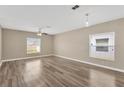 Bright living room with wood-style flooring, two large windows and ceiling fan at 1210 Trailwater St, Ruskin, FL 33570