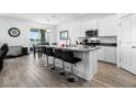 Bright kitchen features a center island with bar seating, white cabinetry, and stainless steel appliances at 13821 Kinsale St, Riverview, FL 33579