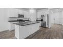 Modern kitchen featuring white cabinetry, stainless steel appliances, and a large center island with a sink at 13821 Kinsale St, Riverview, FL 33579