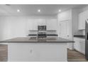 Bright kitchen features a large island, stainless steel appliances and white cabinetry at 13821 Kinsale St, Riverview, FL 33579