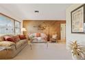Comfortable living room with wood-paneled wall, plush seating, and neutral carpet, creating a cozy atmosphere at 14006 79Th Ave, Seminole, FL 33776