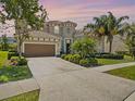 Charming two-story home with well-manicured landscaping, tile roof and a two-car garage at 14209 Quintessa Ln, Lithia, FL 33547