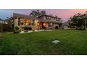 Well-maintained home with lush lawn, landscaping, and exterior stone accents at dusk at 14344 83Rd Pl, Seminole, FL 33776
