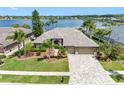 Aerial view of a beautiful home on a large lot with a lake view, lush landscaping, and a paver driveway at 16529 Ivy Lake Dr, Odessa, FL 33556