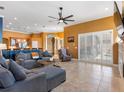 Spacious living room with tile floors, ceiling fan, and sliding glass doors that lead to the outdoor area at 16529 Ivy Lake Dr, Odessa, FL 33556
