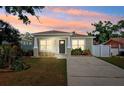 Charming single-story home features a well-manicured lawn and a concrete driveway at sunset at 2410 26Th S St, St Petersburg, FL 33712