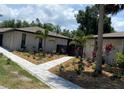 Beautifully landscaped home exterior showcasing a patterned walkway and thriving tropical plants at 24549 Nova Ln, Punta Gorda, FL 33980
