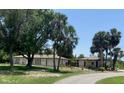 Expansive property featuring a modern home design complemented by mature trees and lush landscaping at 24549 Nova Ln, Punta Gorda, FL 33980