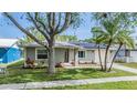 Inviting single-Gathering home featuring mature trees, lush lawn, and solar panels for energy efficiency at 2779 Diane Ter, Clearwater, FL 33759