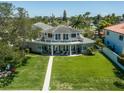 Expansive home features a large balcony, lush backyard, and direct waterfront access at 3 Paradise Ln, Treasure Island, FL 33706