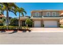 Beautiful two-story home with a paver driveway, tropical landscaping, and a spacious two-car garage at 3 Paradise Ln, Treasure Island, FL 33706