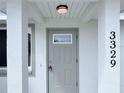 Front entry door with a light gray finish and small window at 3329 Roxbury Dr, Holiday, FL 34691