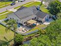 Aerial view of a backyard oasis with a pool, hot tub, covered patio, and a fenced yard backing to a canal at 380 Palmdale Dr, Oldsmar, FL 34677