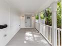 Covered front porch with white railing, sconce lighting, and space for relaxing at 445 33Rd N Ave, St Petersburg, FL 33704