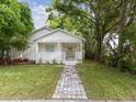 Inviting home exterior featuring a brick walkway, front porch, and lush landscaping at 445 33Rd N Ave, St Petersburg, FL 33704