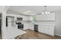 Modern kitchen with stainless steel appliances, white cabinets, and a breakfast bar counter at 5300 6Th S Ave, St Petersburg, FL 33707