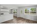 Open-concept living space with wood flooring and a view of the front door and kitchen area at 5300 6Th S Ave, St Petersburg, FL 33707