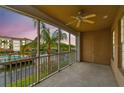 Screened in balcony featuring a ceiling fan and a beautiful view of the pond and nearby building at 7903 Seminole Blvd # 2204, Seminole, FL 33772