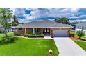 Charming brick home with a well-maintained lawn, long driveway and beautiful garden at 829 Golf Island Dr, Apollo Beach, FL 33572