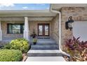 Inviting front entrance with beautiful brick facade, stylish lighting, and lush landscaping at 829 Golf Island Dr, Apollo Beach, FL 33572