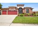 Charming single-story home featuring a well-manicured lawn, mature landscaping, and a two-car garage at 8437 White Poplar Dr, Riverview, FL 33578