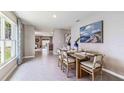 Bright dining area with tile flooring, modern furnishings, and large window with patterned curtains at 10612 Dusty Boot Rd, Land O Lakes, FL 34638