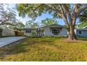 Charming single-story home with well-kept lawn, mature trees, neutral stucco, and tasteful window shutters at 1543 Gentry St, Clearwater, FL 33755