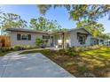 Charming single-story home with well-kept lawn, mature trees, neutral stucco, and tasteful window shutters at 1543 Gentry St, Clearwater, FL 33755