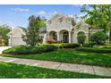 Beautiful home showcasing an inviting front yard, lush landscaping, and mature tree coverage at 1655 Eagles Reach, Tarpon Springs, FL 34688