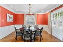 Elegant dining room featuring vibrant walls, a decorative chandelier, and beautiful hardwood floors at 2512 W Sunset Dr, Tampa, FL 33629