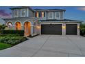 Charming two-story home featuring a three-car garage, arched entryway, and meticulously landscaped front yard at 28683 Lucero Ln, Wesley Chapel, FL 33543