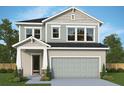 Charming two-story home featuring a symmetrical facade, gray siding, and a two-car garage at 28764 Jujube Rd, Wesley Chapel, FL 33543