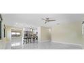 Bright living room with glossy tile floors, fan and bar stool seating at kitchen counter at 3214 E Maritana Dr, St Pete Beach, FL 33706