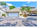 Home exterior with a spacious garage and covered parking, complimented by palm trees and manicured landscaping at 4611 Duhme Rd # 1A, St Petersburg, FL 33708