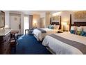 Inviting hotel bedroom with two beds, cool blue carpet, and sliding doors to a balcony at 5500 Gulf Blvd # 4228, St Pete Beach, FL 33706