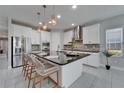 Modern kitchen with stainless steel appliances, a large island, and sleek countertops at 606 Winterside Dr, Apollo Beach, FL 33572