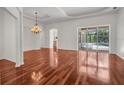 Bright, open living room with hardwood floors, chandelier, and sliding glass doors to the pool at 6205 Ibispark Dr, Lithia, FL 33547